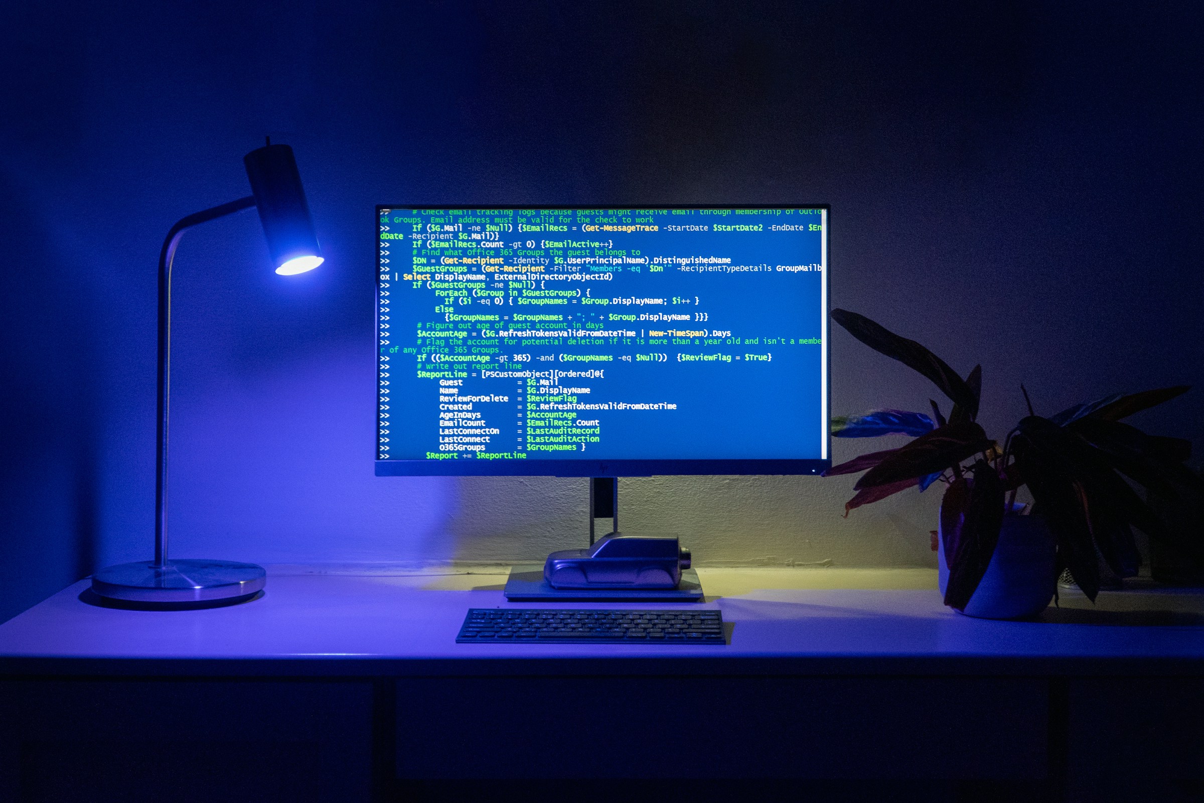 Monitor displaying code in a dimly lit workspace