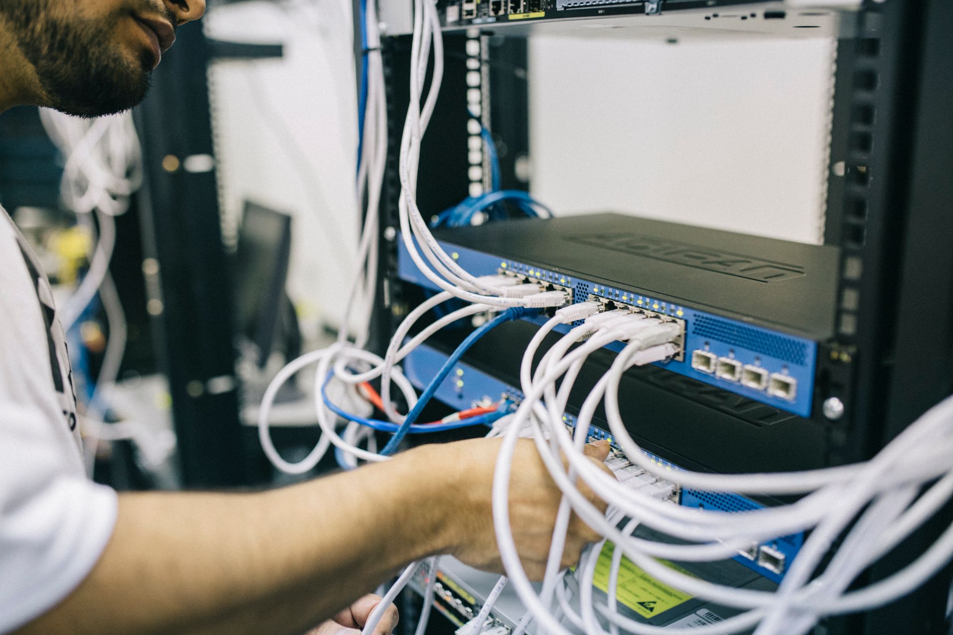 Technician working with ethernet cables on a network switch