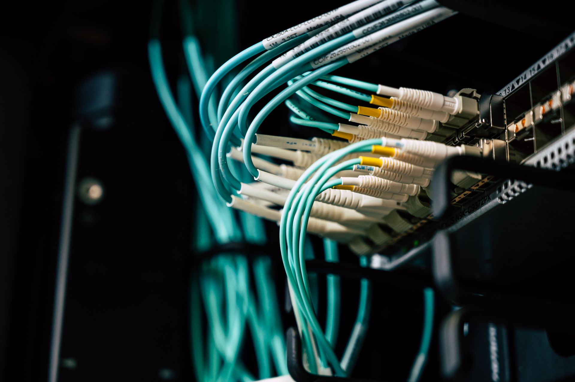 Neatly organized teal network cables in a server rack