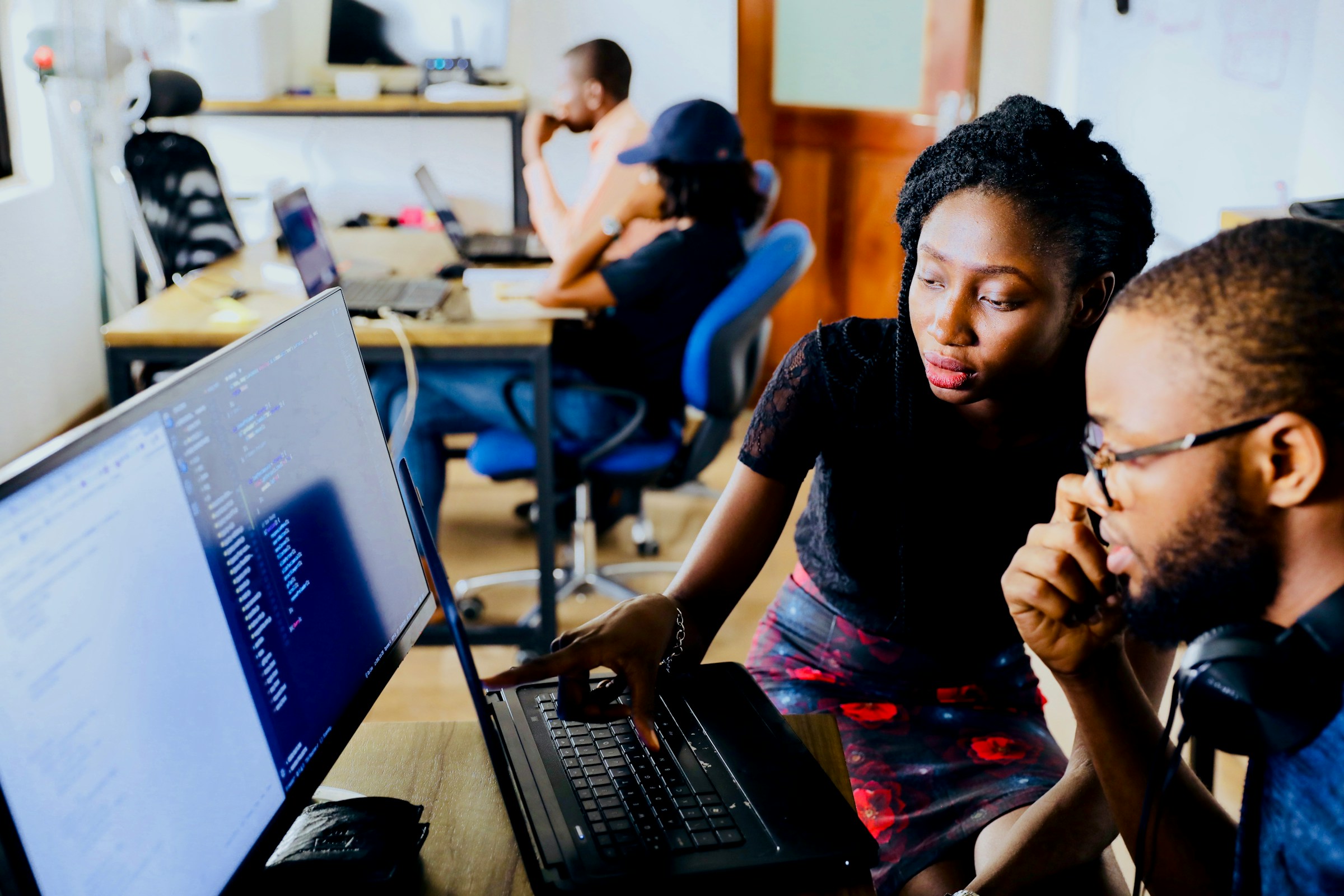 Two engineers working together on laptops in a bright office