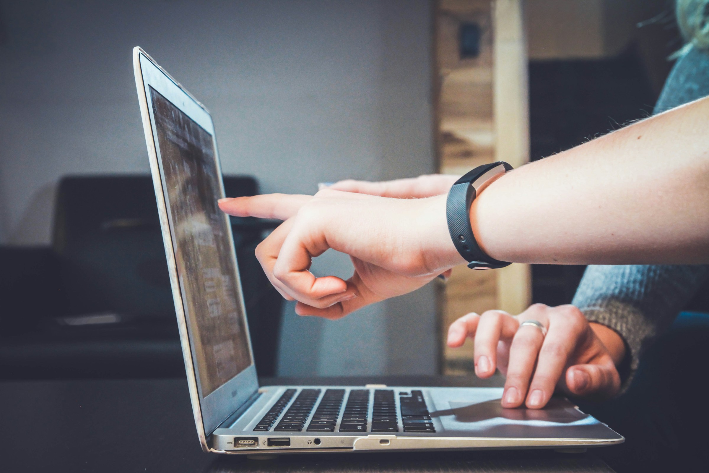 Hands pointing at a laptop screen during a working session