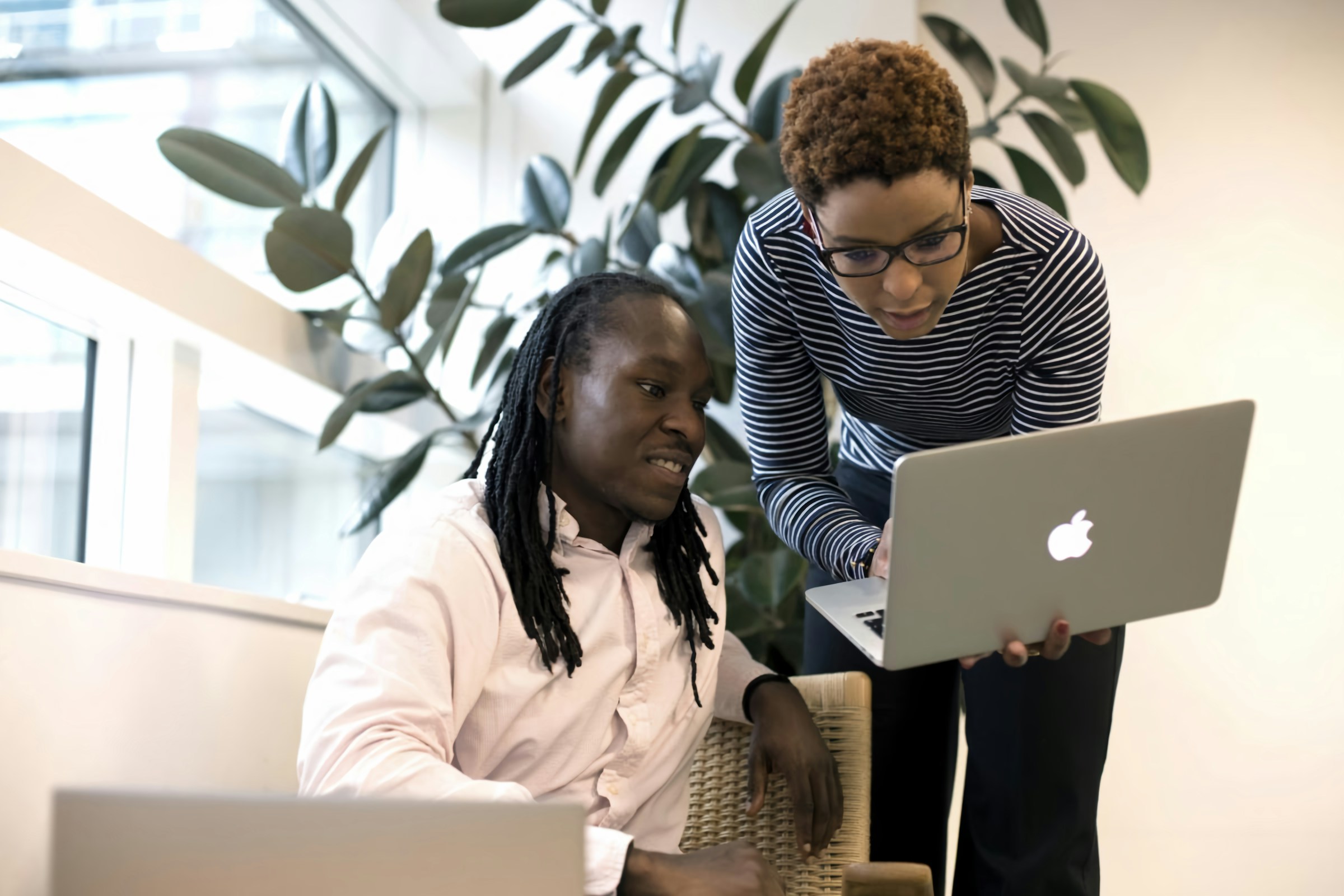 Two colleagues reviewing work together on a laptop