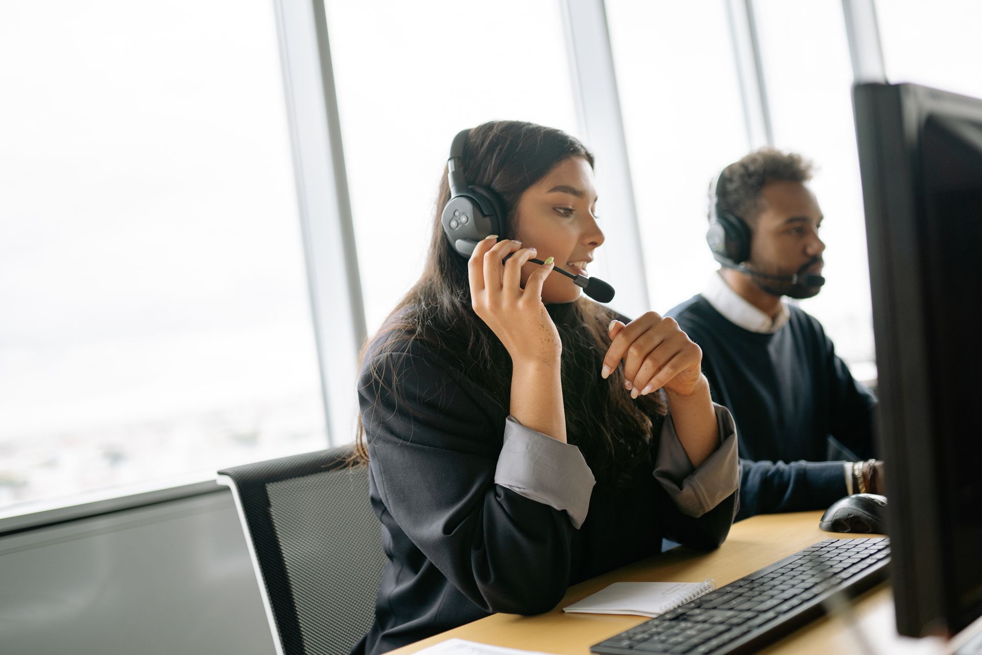 Support specialist wearing a headset at an office desk